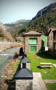 a stone building with a stove next to a river at Albergue Armaia Artepea in Urzainqui