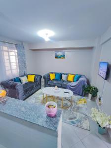 ein Wohnzimmer mit einem Sofa und einem Tisch in der Unterkunft Luxe Happy Home 254 Furnished Apartments in Nairobi