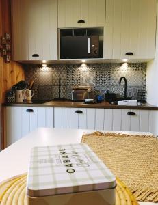 una cocina con una mesa con un cartel. en Maison de vacances 2 chambres plages lac à 600m proche Dune du Pilat Océan dans propriété privée, en Sanguinet