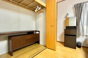 a room with a tv and a desk and a door at 雅 芦ノ湖 別荘 箱根 Miyabi Ashinoko villa hakone in Sekishoato