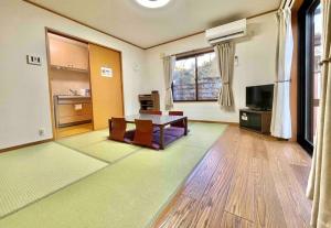 a large living room with a table and a tv at 雅 芦ノ湖 別荘 箱根 Miyabi Ashinoko villa hakone in Sekishoato