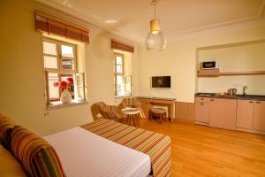 a bedroom with a bed and a table and a kitchen at Comfortable Flat with Jacuzzi near Hadrian's Gate in Antalya
