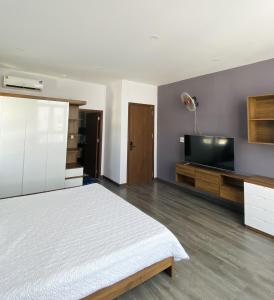 a bedroom with a bed and a flat screen tv at Trường Phúc Vinh Hotel in Phan Thiet