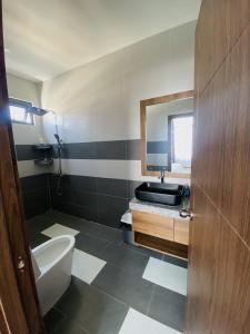 a bathroom with a sink and a toilet and a mirror at Trường Phúc Vinh Hotel in Phan Thiet