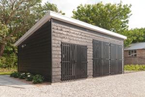 eine große schwarze Garage mit zwei Türen darauf in der Unterkunft Vakantieverblijf de Trommel in Domburg