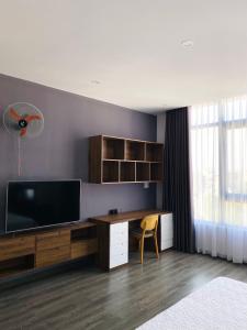 a room with a tv and a desk with a television at Trường Phúc Vinh Hotel in Phan Thiet