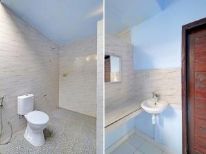 a bathroom with a toilet and a sink at OYO 92401 Hotel Mustika in Mendaya