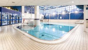 a large swimming pool in a large building at Holiday Inn London Sutton, an IHG Hotel in Sutton