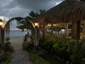 Comfy Stay in Jamaica -Enjoy 7 Miles of White Sand Beach! villa في نيغريل: منتجع بمبنى من القش والشاطئ +14 صورة