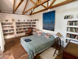 a bedroom with a bed in a room with book shelves at Weaver Cottages in Harare