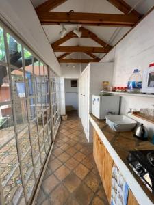 uma cozinha com uma grande janela e um balcão em Weaver Cottages em Harare
