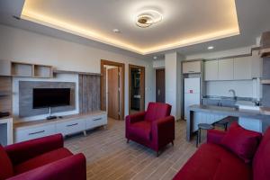 a living room with red furniture and a kitchen at Afyon Regulus Thermal Apart Hotel & Villas in Gazligol