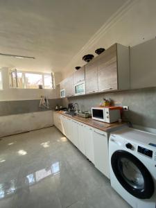 a kitchen with a washing machine and a microwave at CHEMPION HOSTEL BAKU in Baku