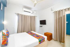 1 dormitorio con 1 cama y TV. en FabHotel Silverkey, en Calcuta
