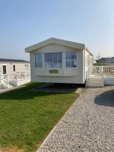 una casa mobile è seduta sull'erba di Woodberry (Acorn Caravan Holidays Newquay) a Crantock