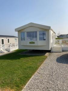 a mobile home is sitting on the grass at Woodberry (Acorn Caravan Holidays Newquay) in Crantock