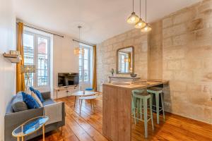 a kitchen and living room with a couch and a table at Appartements Climatises en Hyper Centre in Bordeaux