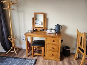 a wooden desk with a mirror and a chair at taigh beag in Fort William