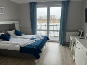 a bedroom with a bed and a large window at Willa Aura Mare in Dziwnów