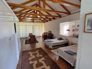 a bedroom with two beds and a table and a chair at Weaver Cottages in Harare