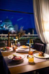 einen langen Tisch mit Teller mit Lebensmitteln drauf in der Unterkunft Crystal Hotel in Belgrad
