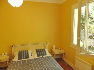 a yellow bedroom with a bed and a window at Villa DOUS REPAOUS pour 5 personnes entre lac et océan in Soorts-Hossegor