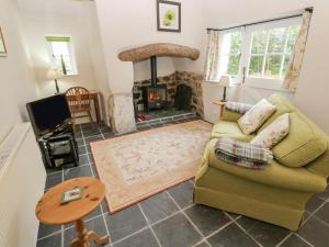 a living room with a couch and a fireplace at Swallows in Saint Keverne