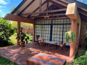 a covered patio with two chairs and a bench at Weaver Cottages in Harare