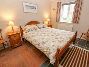 Saint KeverneにあるSwallowsのベッドルーム1室(ベッド1台、テーブル2台、窓付)