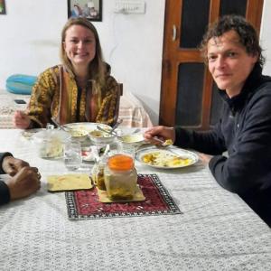 un hombre y una mujer sentados en una mesa comiendo comida en Travel curiosity Homestay en Alwar