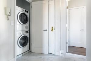 a white laundry room with a washer and dryer at New W Village 2BR w WD Doorman nr Bars NYC-553 in New York