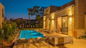 un patio trasero con piscina y sillas y una casa en Bodrum Ortakent Luxury Private Villa with Pool en Bodrum