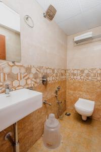 a bathroom with a sink and a toilet at Hotel Purple Orchid in Mumbai