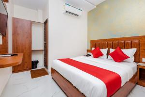 a bedroom with a large bed with red pillows at Hotel Purple Orchid in Mumbai