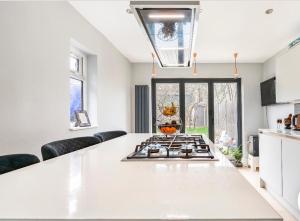 una cucina con piano cottura e piano di lavoro bianco di Cozy private room a Londra
