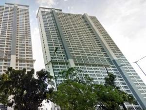 two tall buildings with trees in front of them at Tifolia Apartment Pulomas - Kelapa Gading in Jakarta