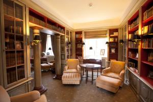 een bibliotheek met stoelen, een tafel en boeken bij Schloss Auel Boutique Hotel & Design Golf Lodge in Lohmar