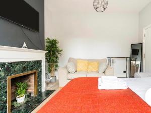 - un salon avec un canapé et une cheminée dans l'établissement Cozy private room, à Londres