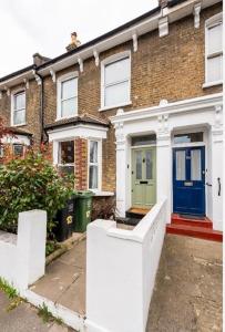 uma casa de tijolos com uma porta azul e verde em Cozy private room em Londres