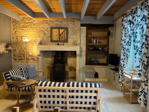ein Wohnzimmer mit einem Kamin und einer Steinmauer in der Unterkunft Gites Le Bois de l'Eglise in Villiers-le-Roux