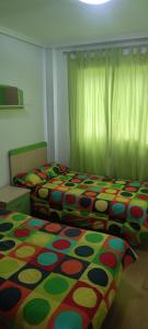 a bedroom with two beds with a colorful blanket at apart paz in Torrevieja