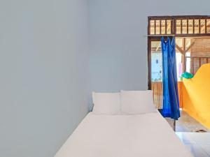 a white bed in a room with a window at SPOT ON 92404 Pondok Ai in Cupel