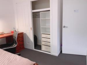 a bedroom with a bed and a desk and a closet at Home Away From Home-(Room1) in Gold Coast