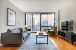 a living room with a couch and a tv at Midtown 2BR w Pool Gym Roof nr Broadway NYC-382 in New York