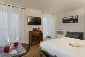 um quarto com uma cama, uma mesa e uma televisão em Superba Studio by Wonderful Italy em Gênova