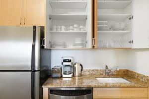 a kitchen with a sink and a refrigerator at Midtown 2BR w Pool Gym Roof nr Broadway NYC-382 in New York
