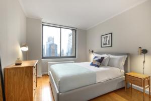 sypialnia z dużym białym łóżkiem i oknem w obiekcie Midtown 2BR w Pool Gym Roof nr Broadway NYC-382 w Nowym Jorku