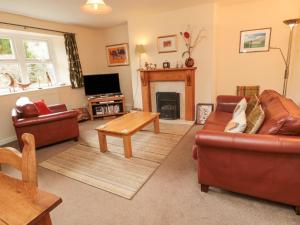 a living room with two couches and a fireplace at Miller's Retreat in Alnwick