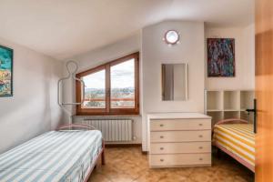 a bedroom with two beds and a dresser and a window at Casa Ischia 66 Vista mare con 3 camere da letto in Numana