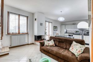 a living room with a brown couch and a kitchen at Casa Ischia 66 Vista mare con 3 camere da letto in Numana